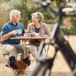 Älteres Paar im Außencafé, im Vordergrund Fahrräder