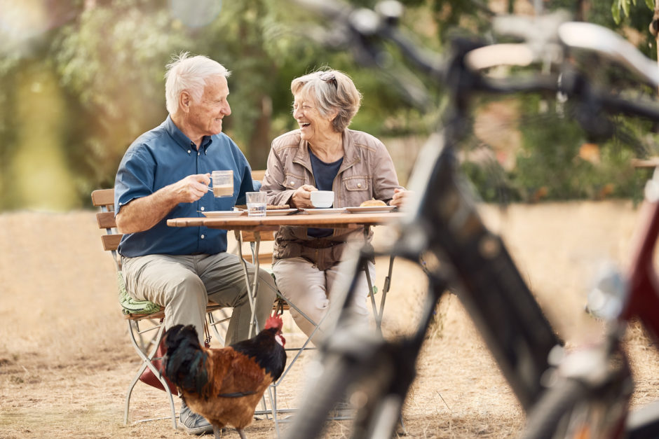 Älteres Paar im Außencafé, im Vordergrund Fahrräder