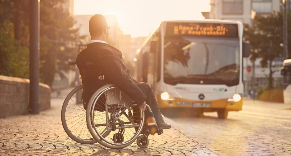 Rollstuhlfahrer an Bushaltestelle