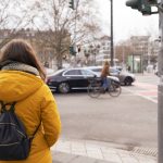 Fußgängerin wartet an Ampel