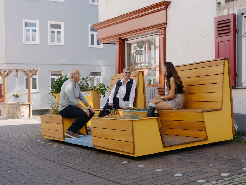 Sitzende Personen auf Parklet-Oase