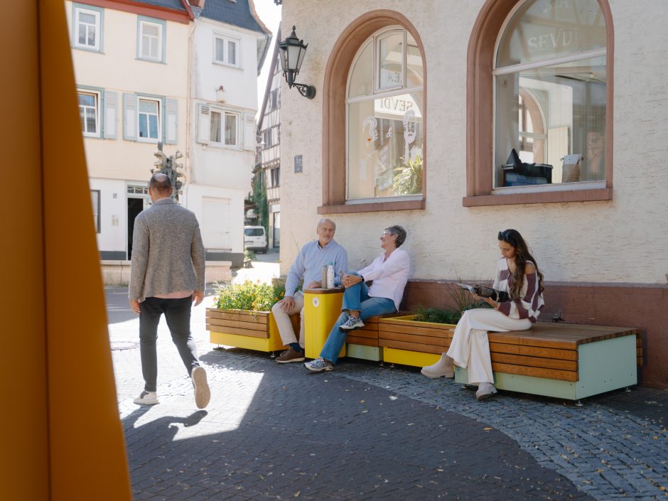 Personengruppe sitzt auf einer Sitzbank